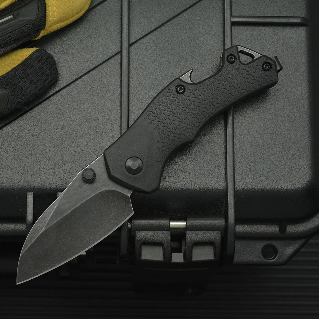 high hardness camping survival knife displayed alongside gloves on a black equipment case.
